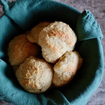 Sourdough drop biscuits in a blue napkin lined basket.
