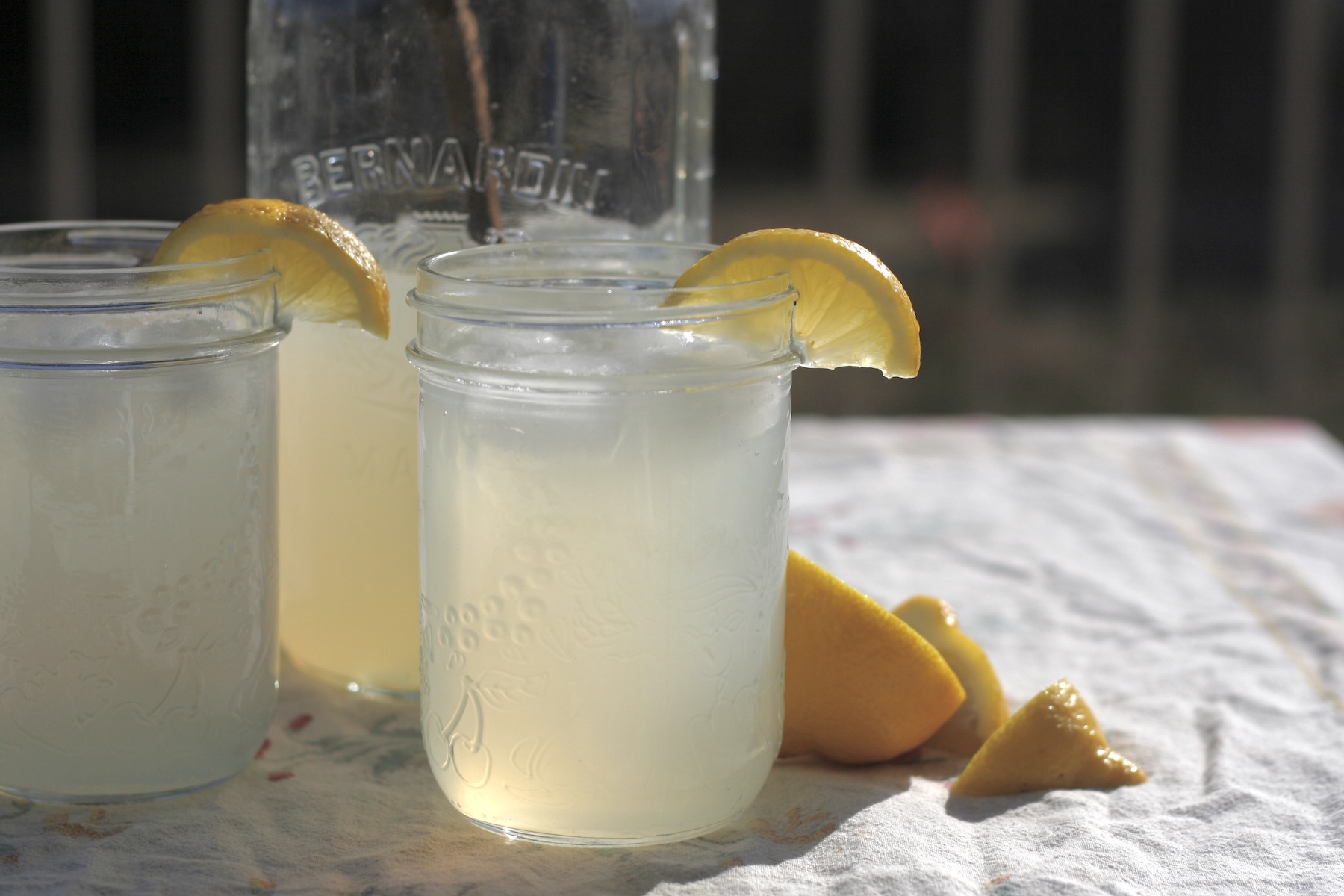 Half gallon jar of lemonade with two filled pint jars.