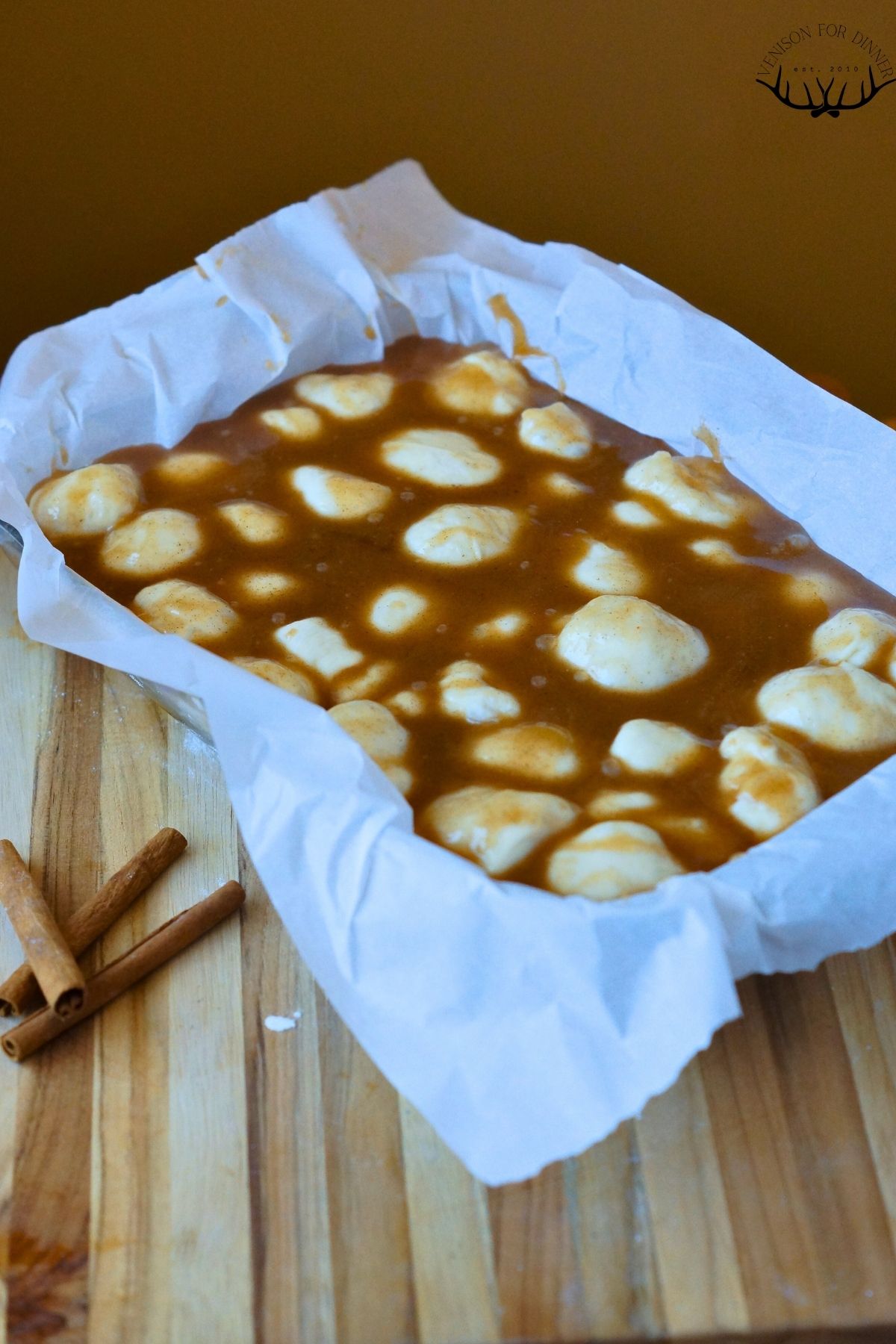 Dough balls in caramel sauce in a baking dish.