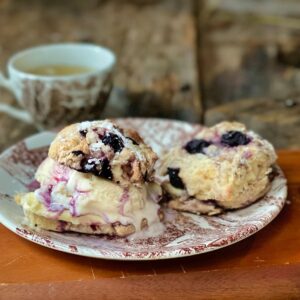 Baked blueberry scones on a china plate.