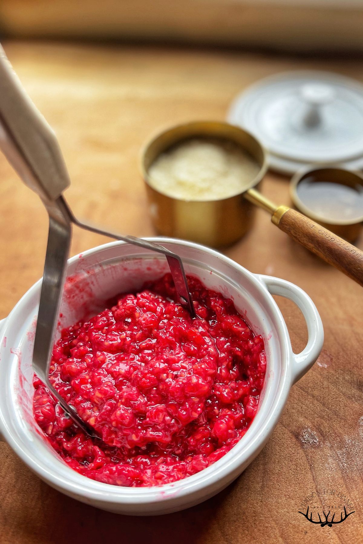 Smashing raspberries with a potato masher.