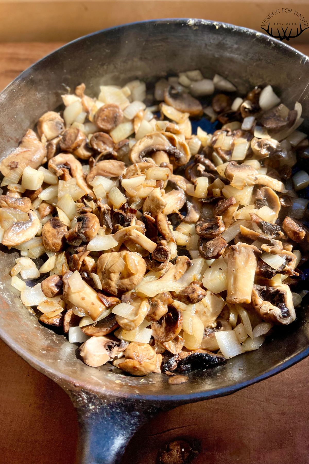 Mushrooms and onions sautรฉed in a pan.