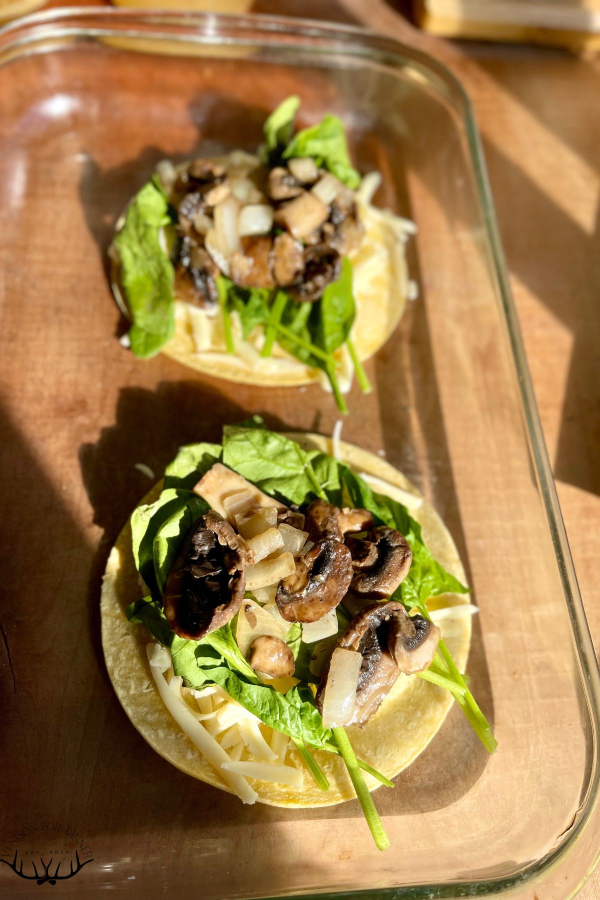 Spinach and mushrooms layers on tortillas.