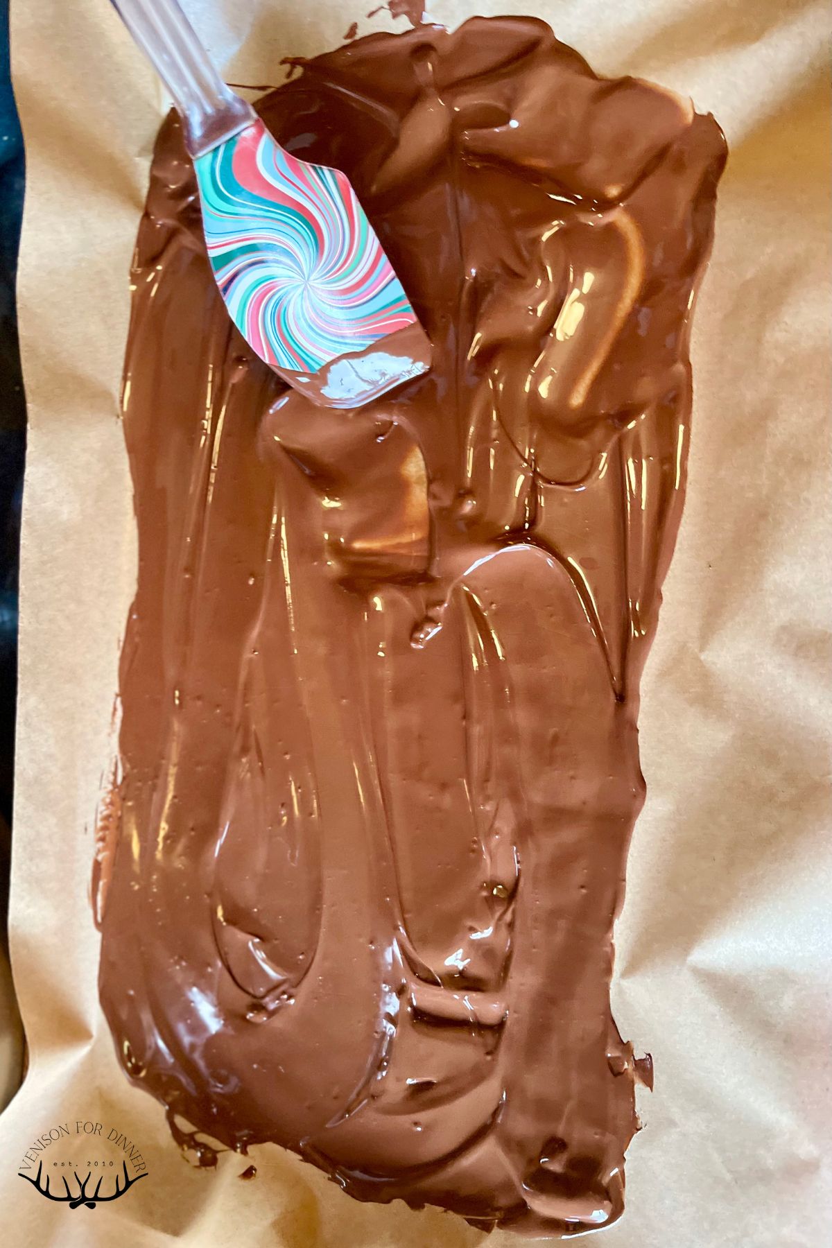 Spreading melted chocolate on parchment.