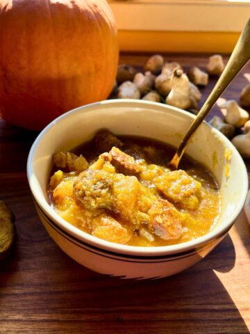 A bowl of pumpkin soup with chorizo sausage.