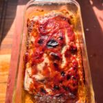 Baked venison meatloaf in a glass loaf pan.