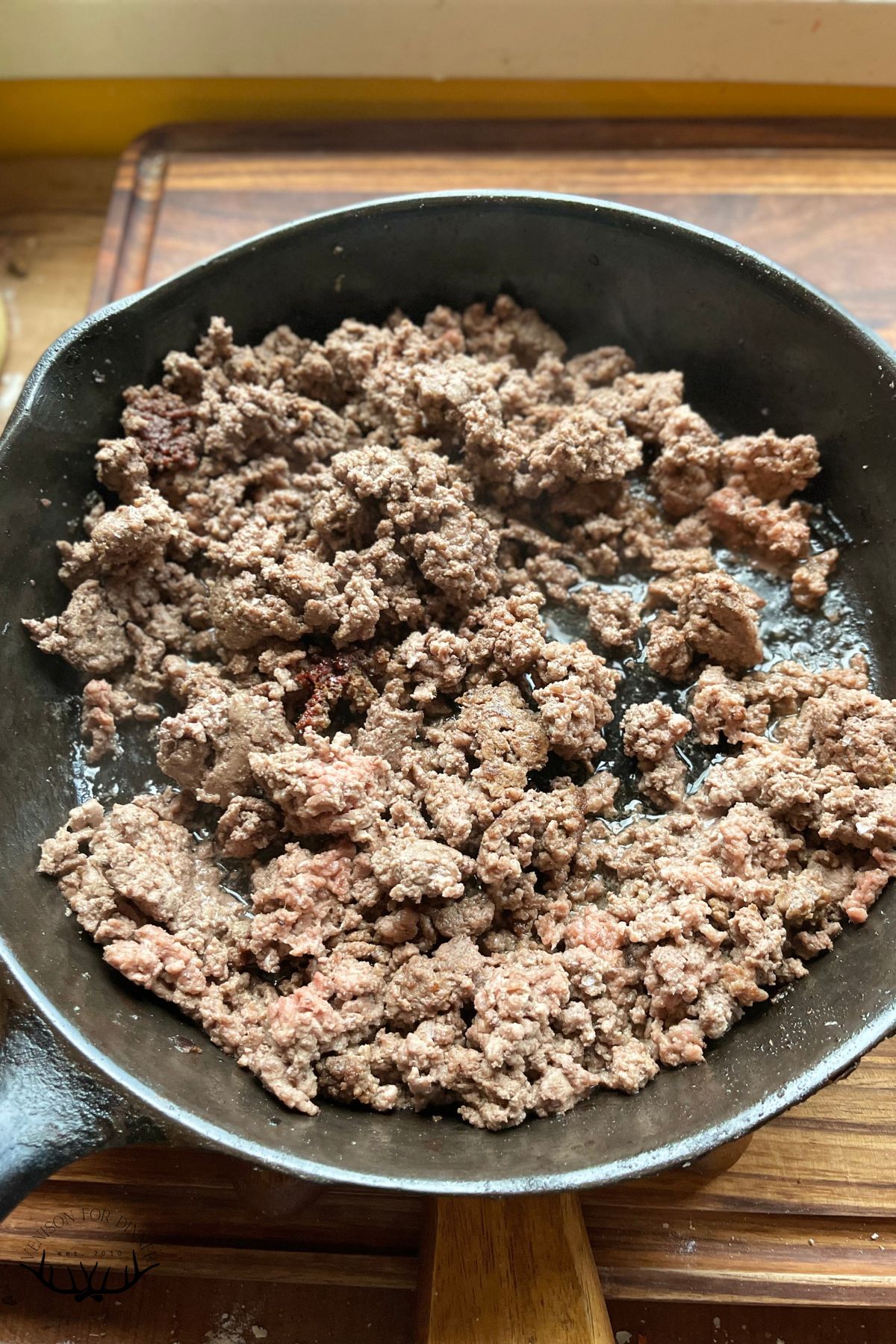 Browned ground venison in a skillet.