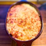 Cheesy topped venison casserole in a baking dish.