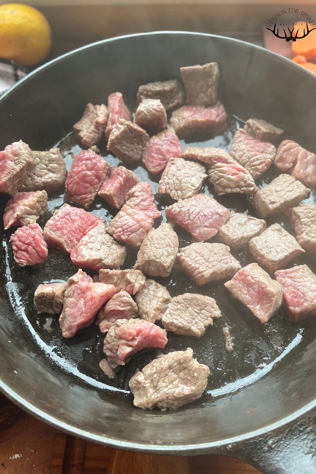 Cubed venison browning in a skillet.