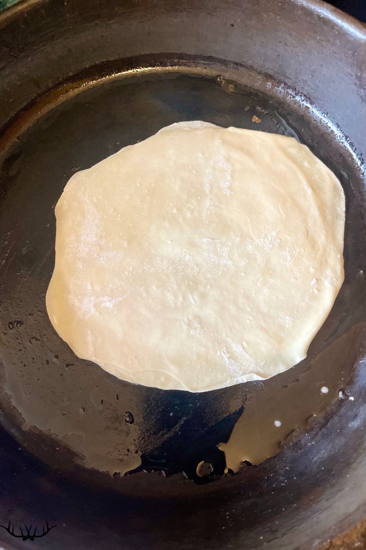 Heating spring roll wrapper in a skillet.