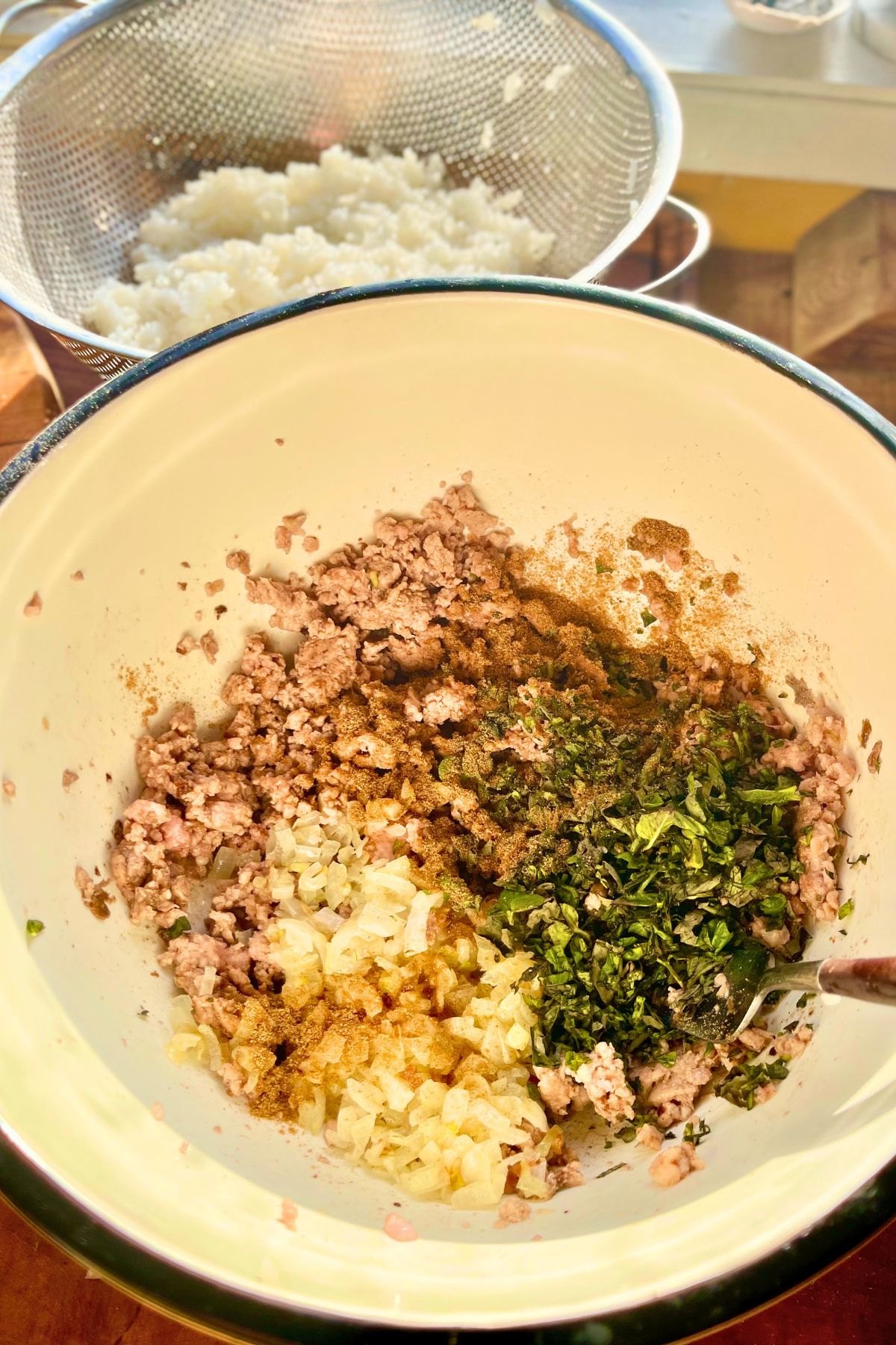 Pork dolmades filling in a mixing bowl.