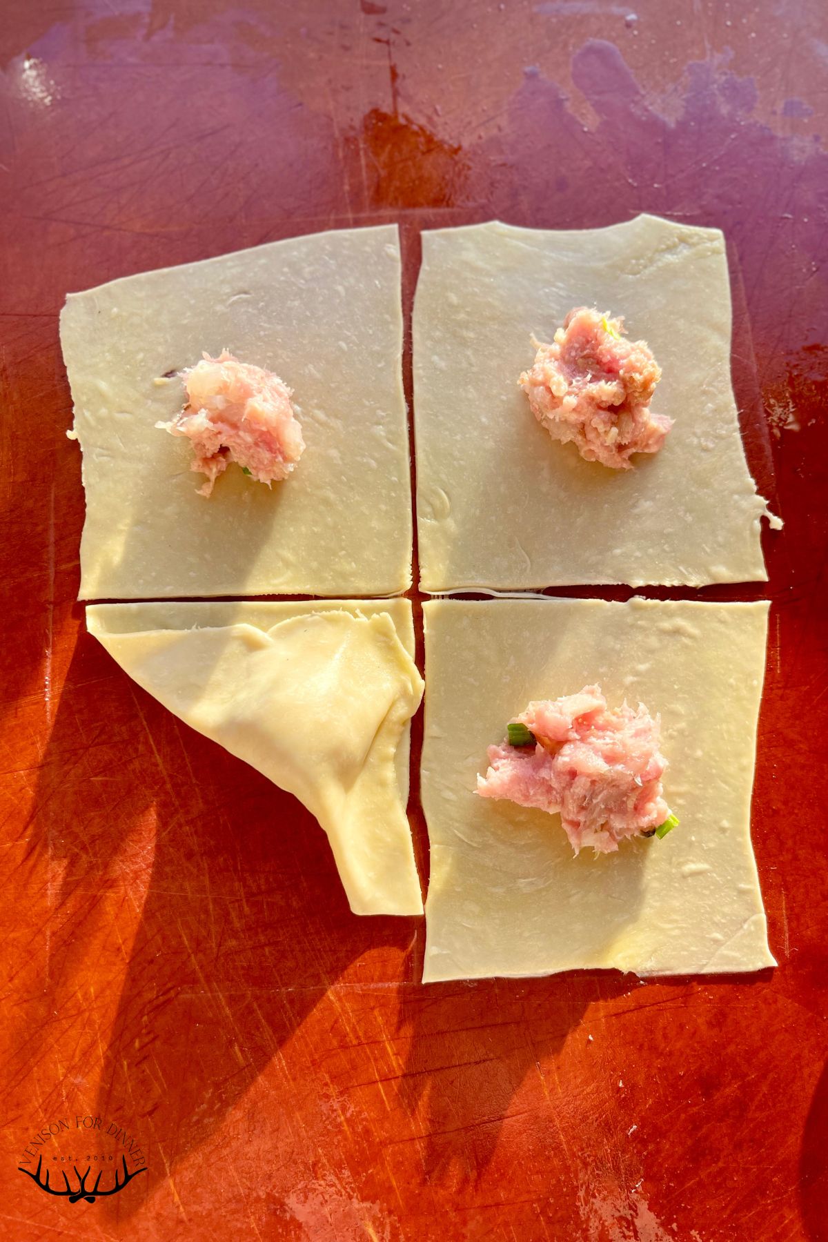 Adding filling to won ton wrappers.