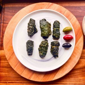 Rolled homemade pork dolmades on a plate.