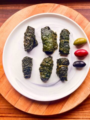 Rolled homemade pork dolmades on a plate.