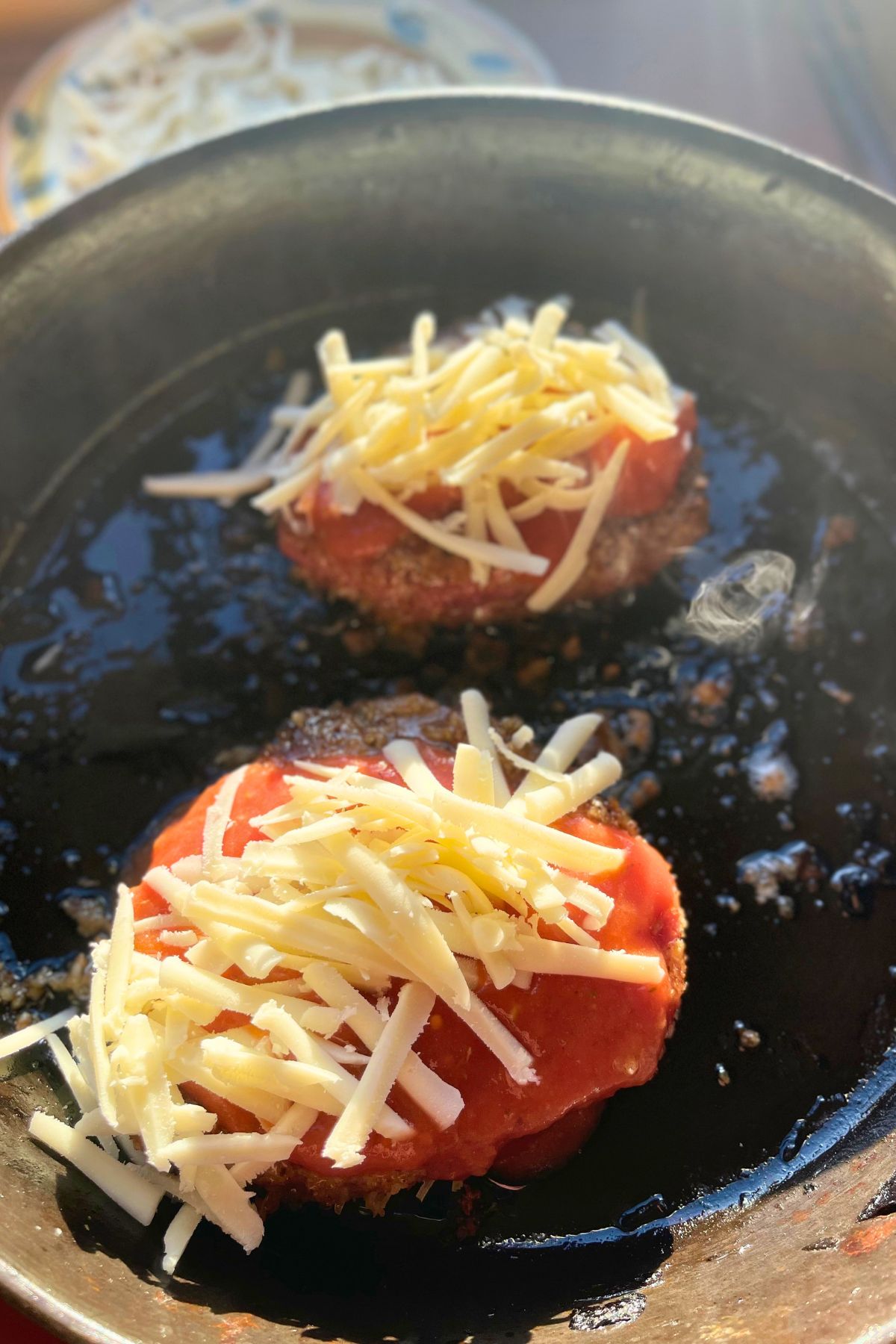 Cheese on top of venison cutlets.