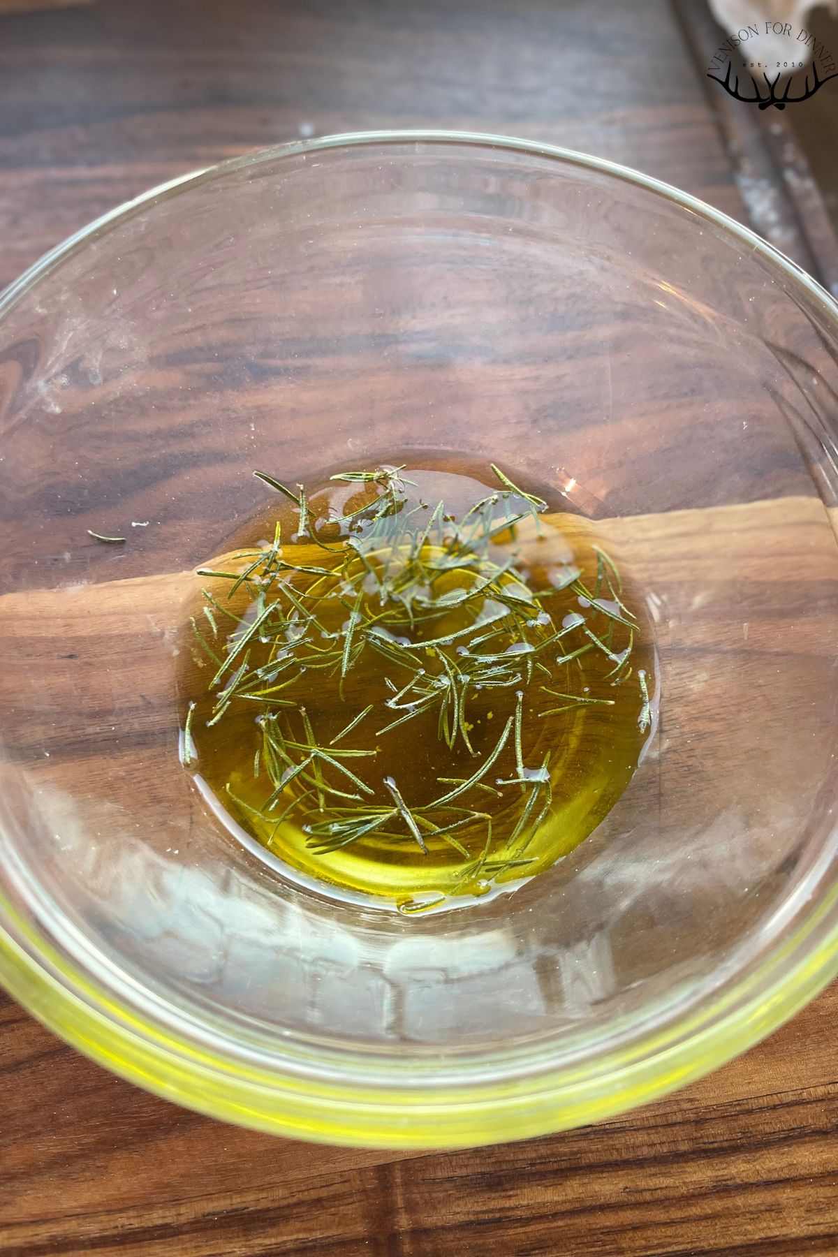 Fresh rosemary in a bowl of olive oil.