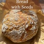 Round loaf of seedy sourdough bread.