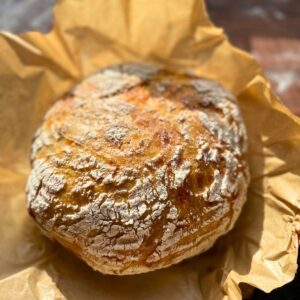 Sourdough loaf with seeds on parchment paper.