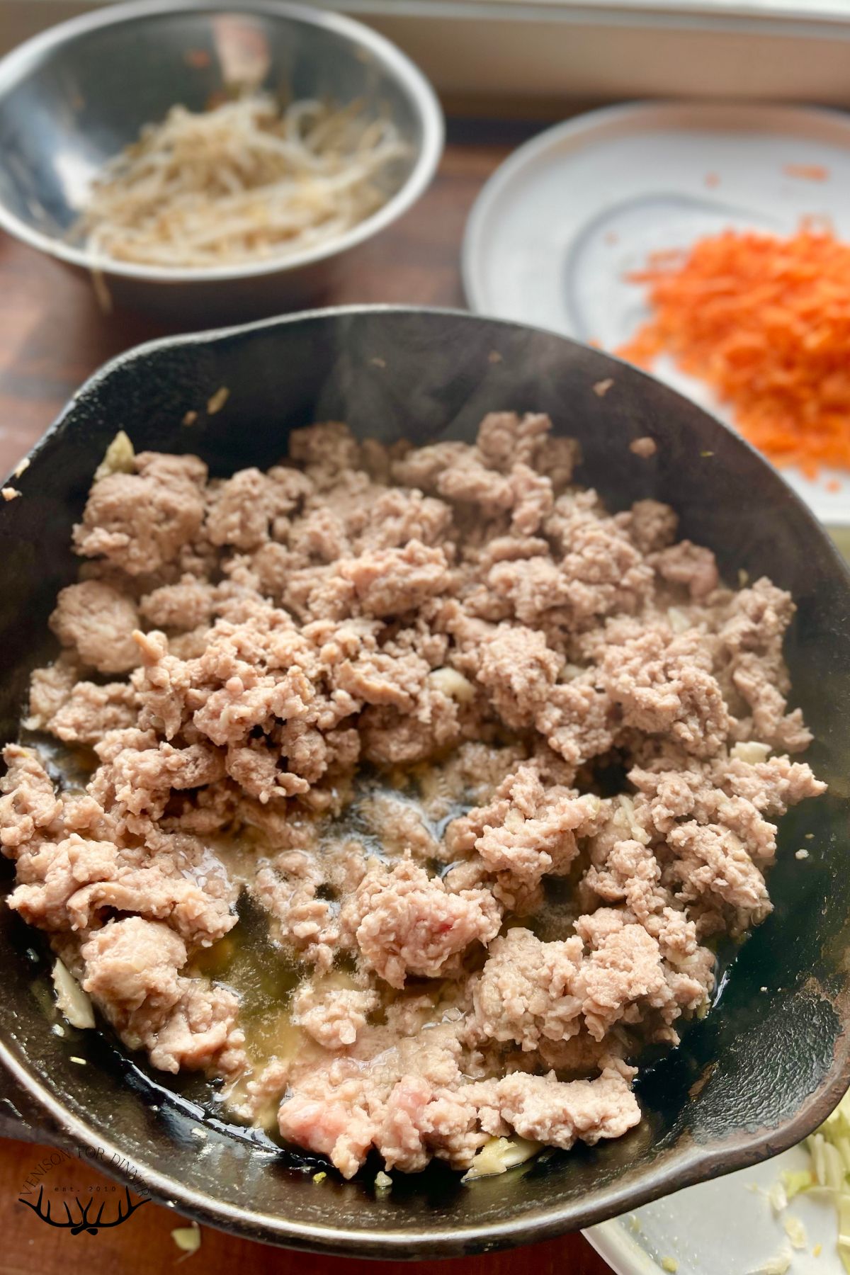 Ground pork in a skillet.