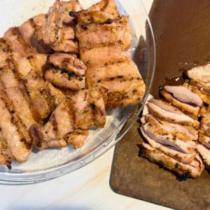 Platter of sliced chicken thighs ready to serve.