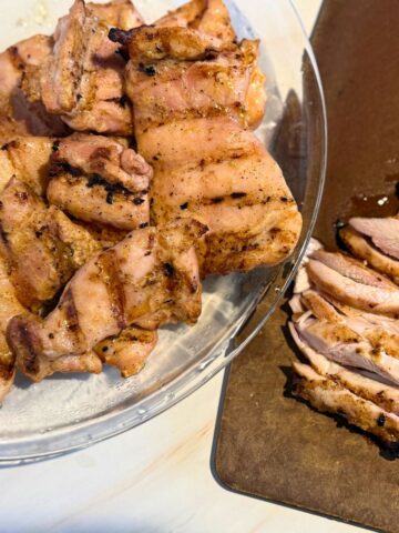 Platter of sliced chicken thighs ready to serve.