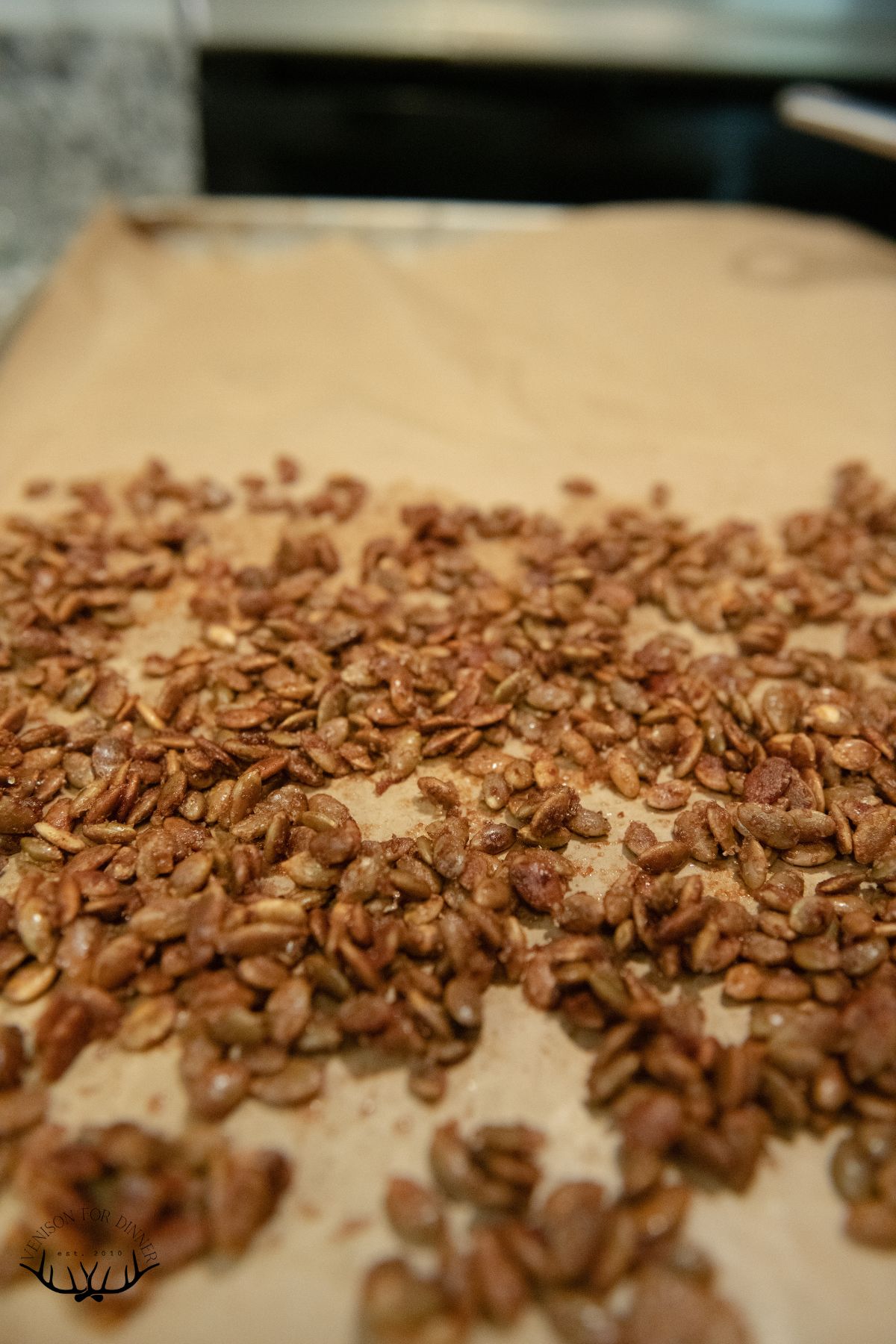 Baked candied pepitas on parchment paper.