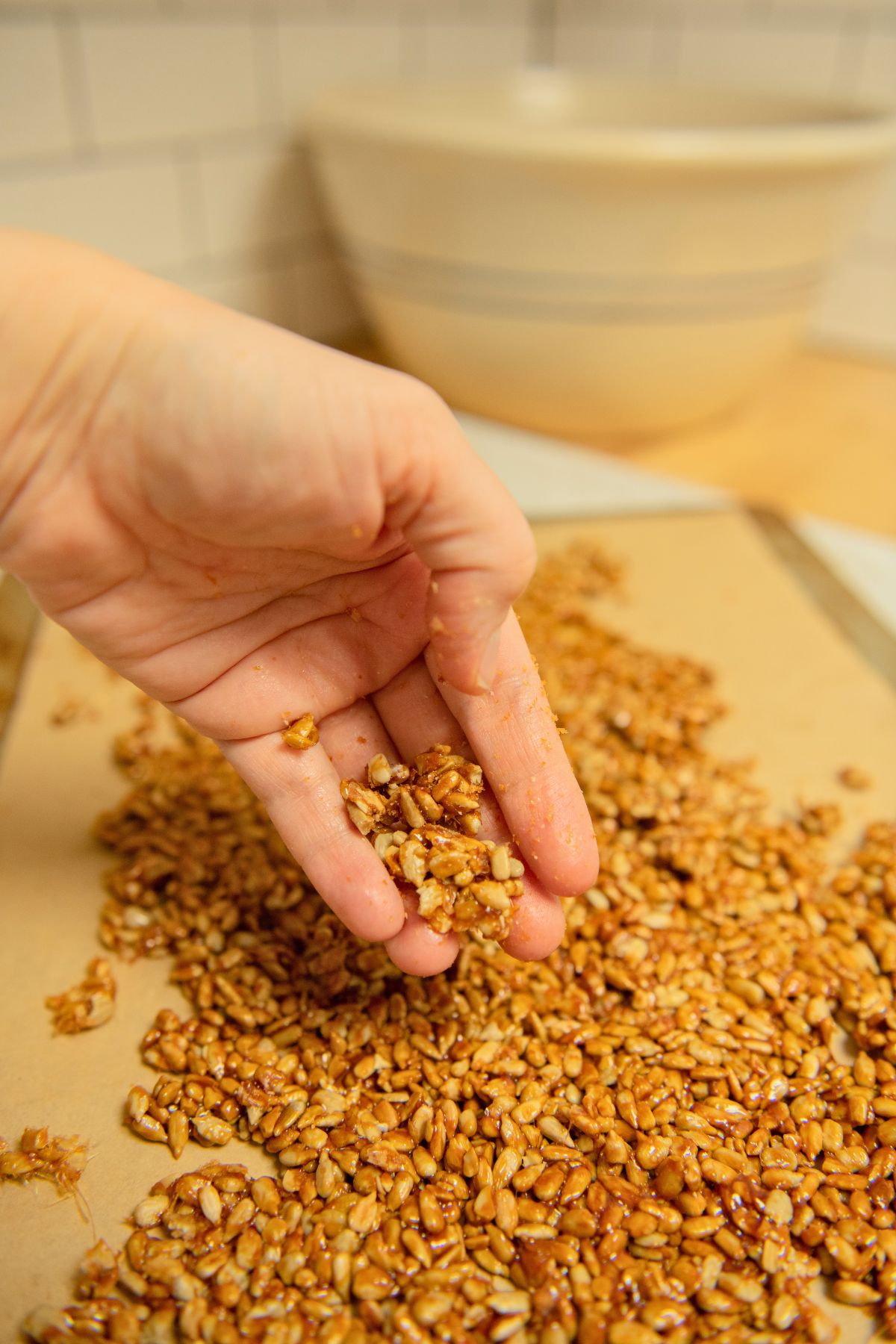 Breaking up candied sunflower seeds.