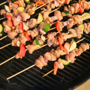 Chicken veggie skewers on a charcoal grill.