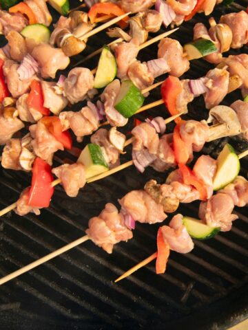 Chicken veggie skewers on a charcoal grill.