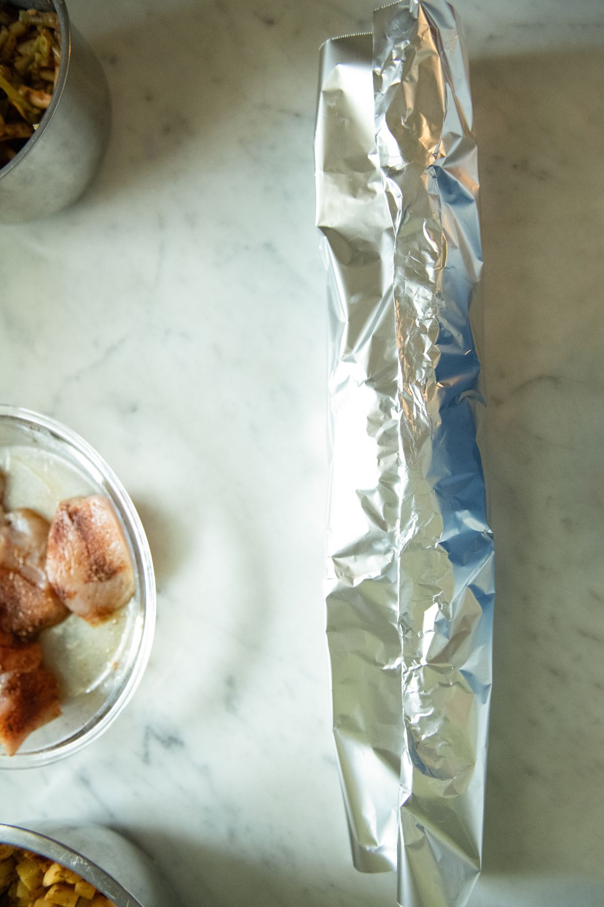 Rolling up foil over chicken.