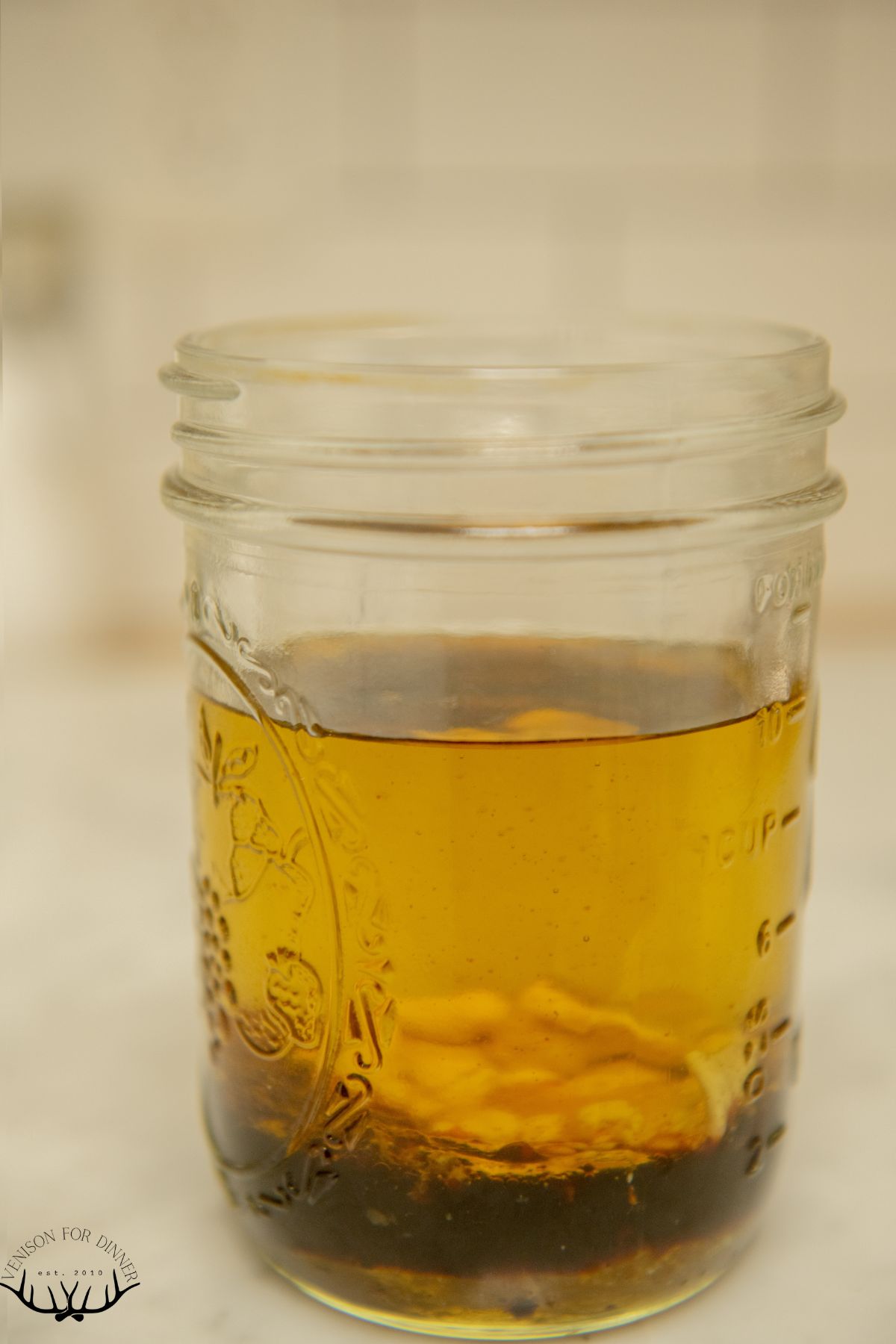 Oil and salad dressing ingredients in a glass jar.