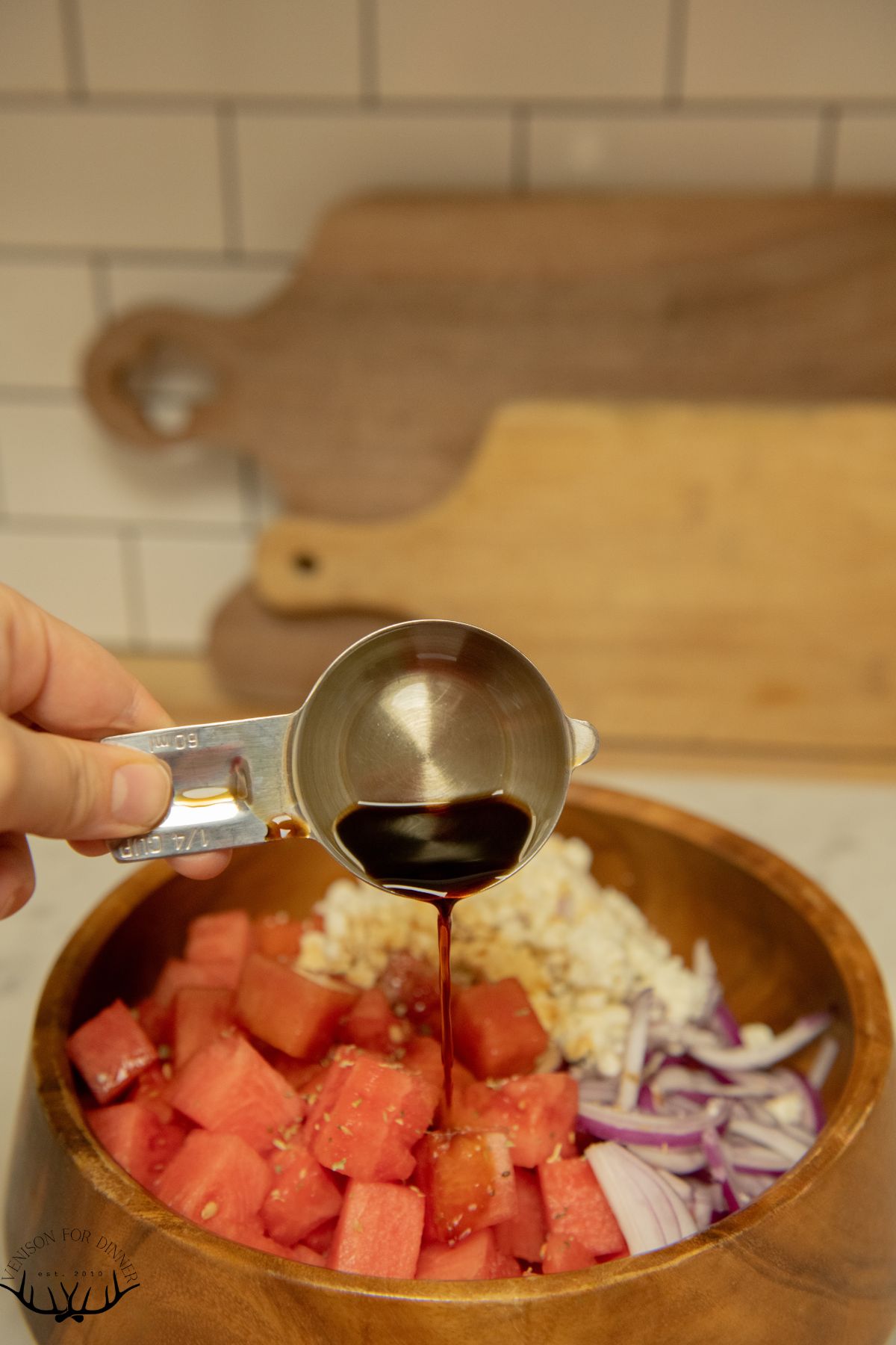 Drizzling balsamic over watermelon.