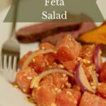 Watermelon feta salad with red onion on plate.