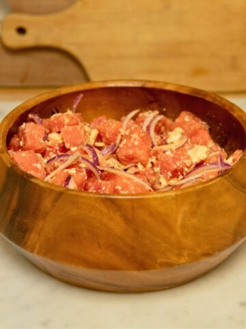 Diced watermelon with red onion in a salad bowl.