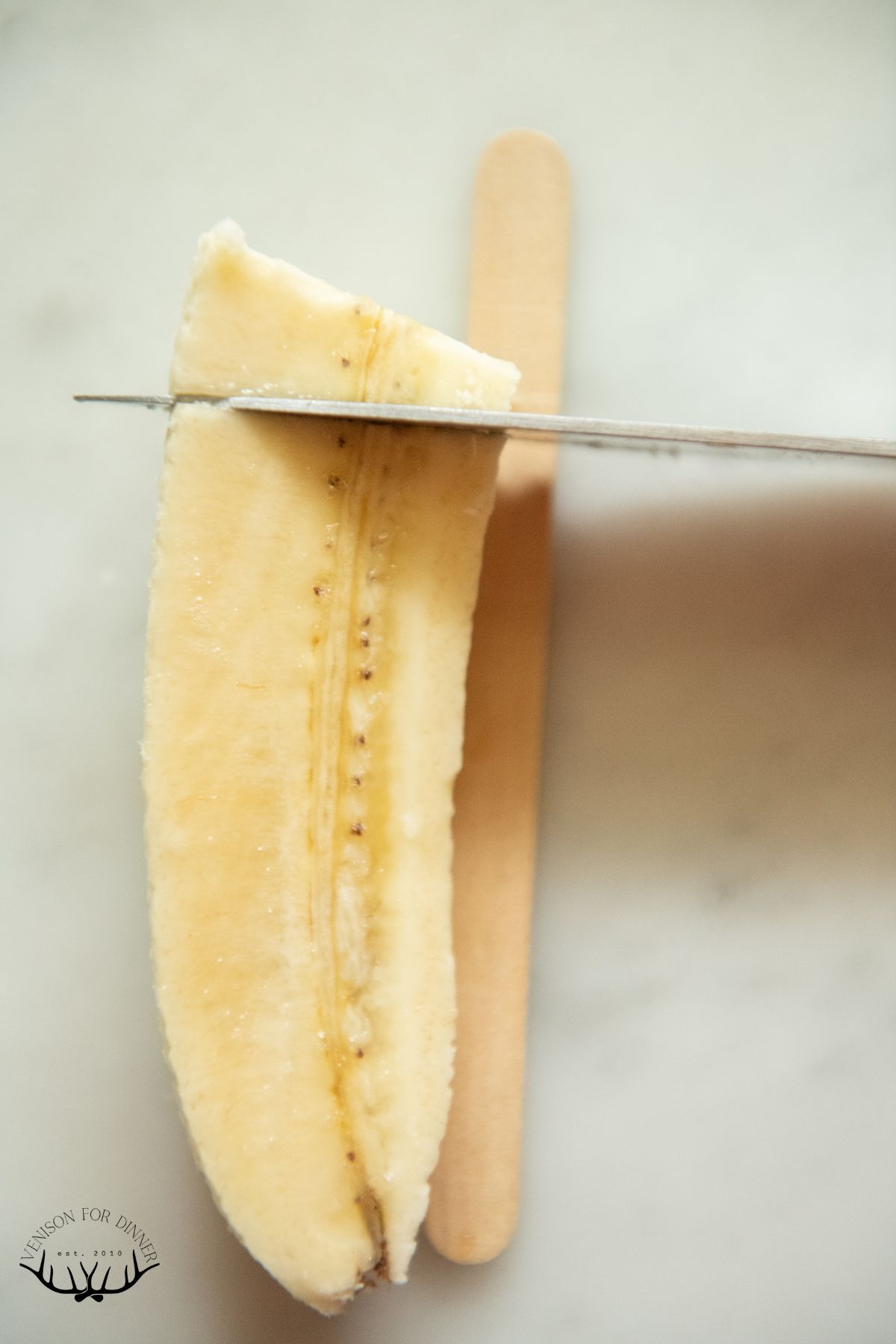 Measuring a banana against a popsicle stick.
