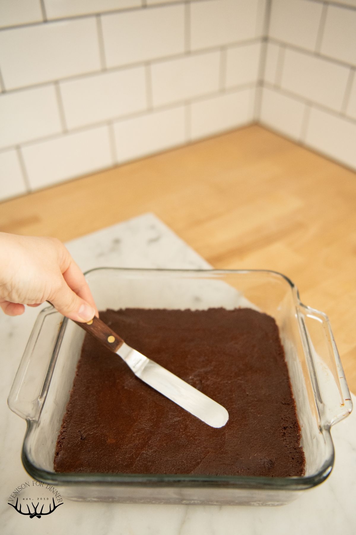 Smoothing brownie batter into a baking dish.