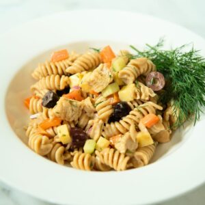 Bowl of chicken pasta salad with fresh dill.