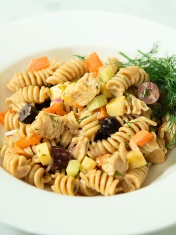 Bowl of chicken pasta salad with fresh dill.