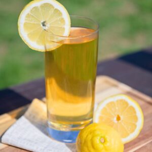 Glass of black iced tea sweetened with honey.