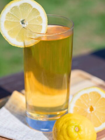 Glass of black iced tea sweetened with honey.