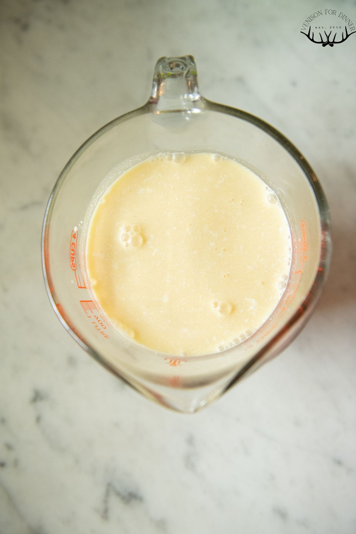 Orange juice and cream in a measuring cup.