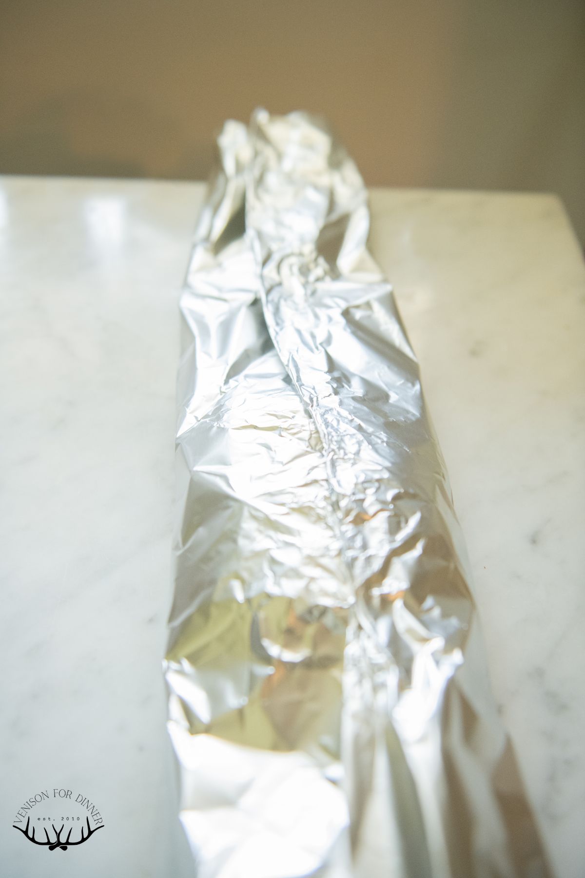 Rolling foil around a pork chop.