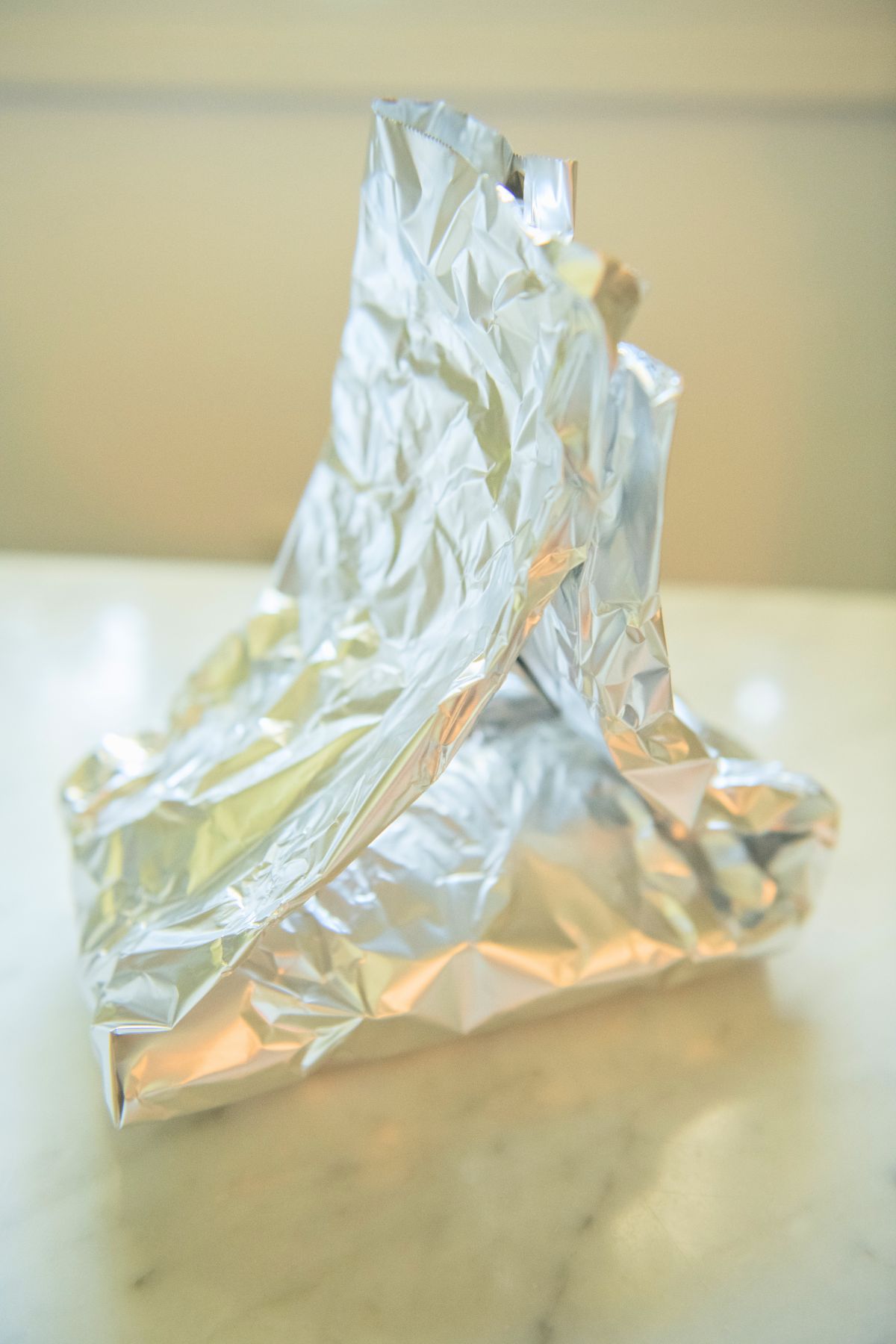 Tenting foil around a pork chop.