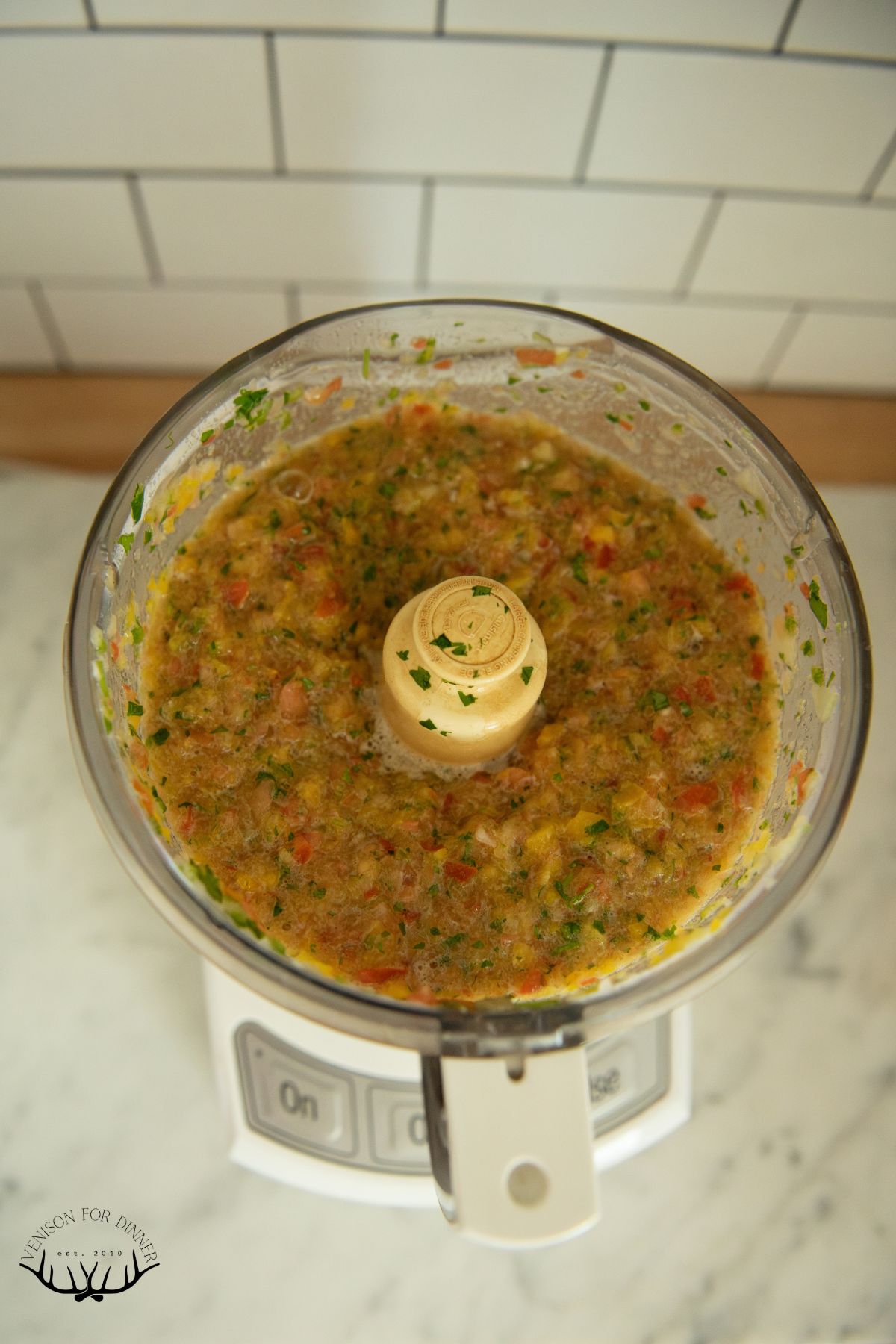 Chopped tomatoes and peppers in a food processor.