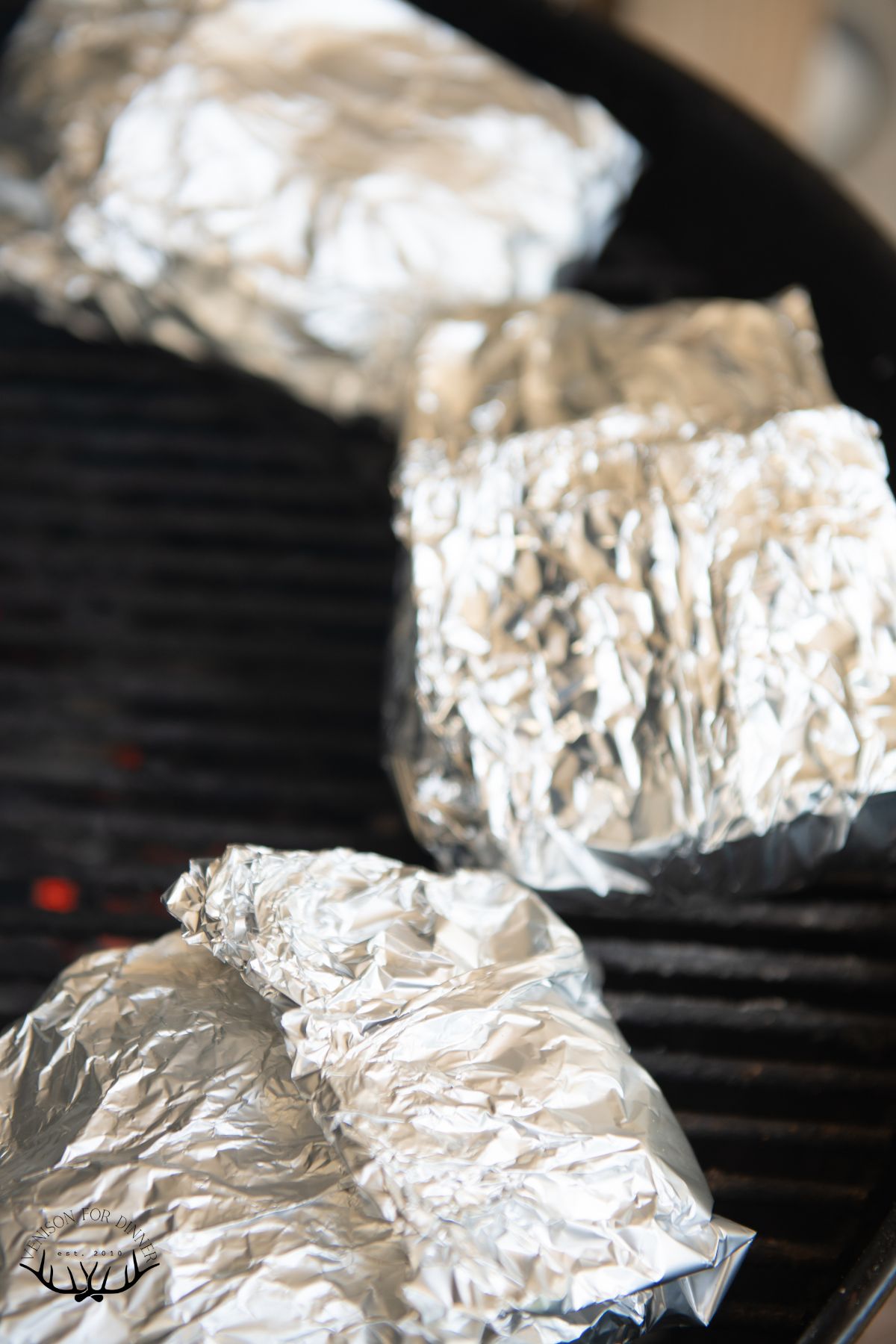 Pork chop foil packs on a grill.