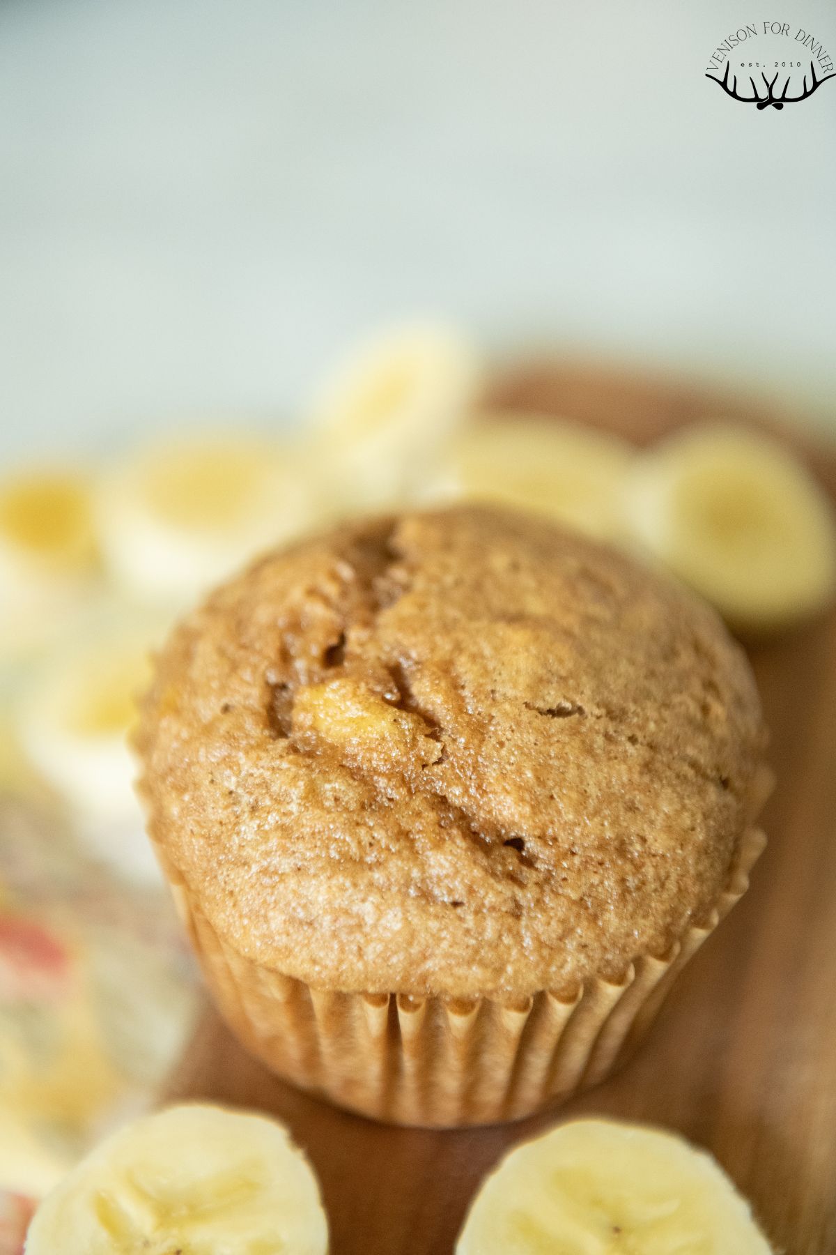 A single banana spelt muffin with banana slices.