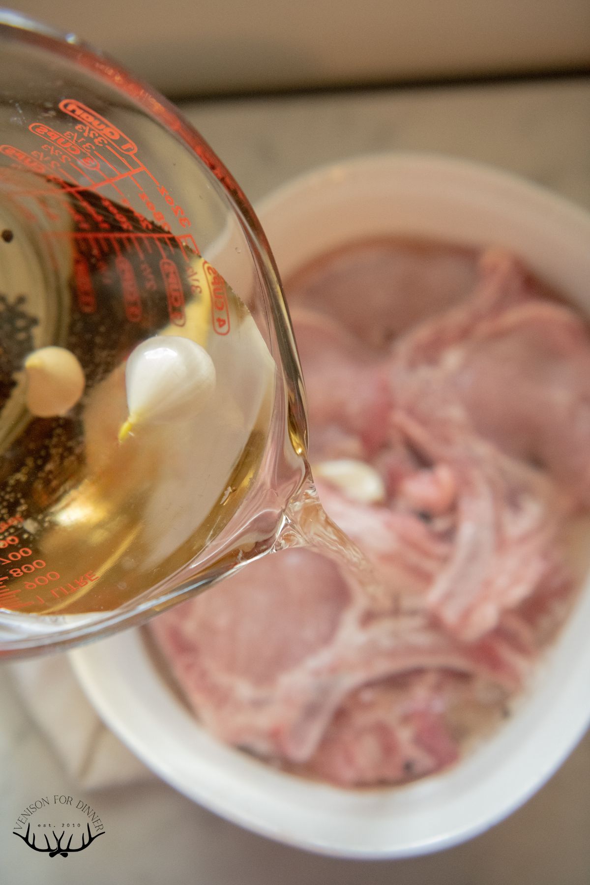 Pouring brine over bone-in pork chops.