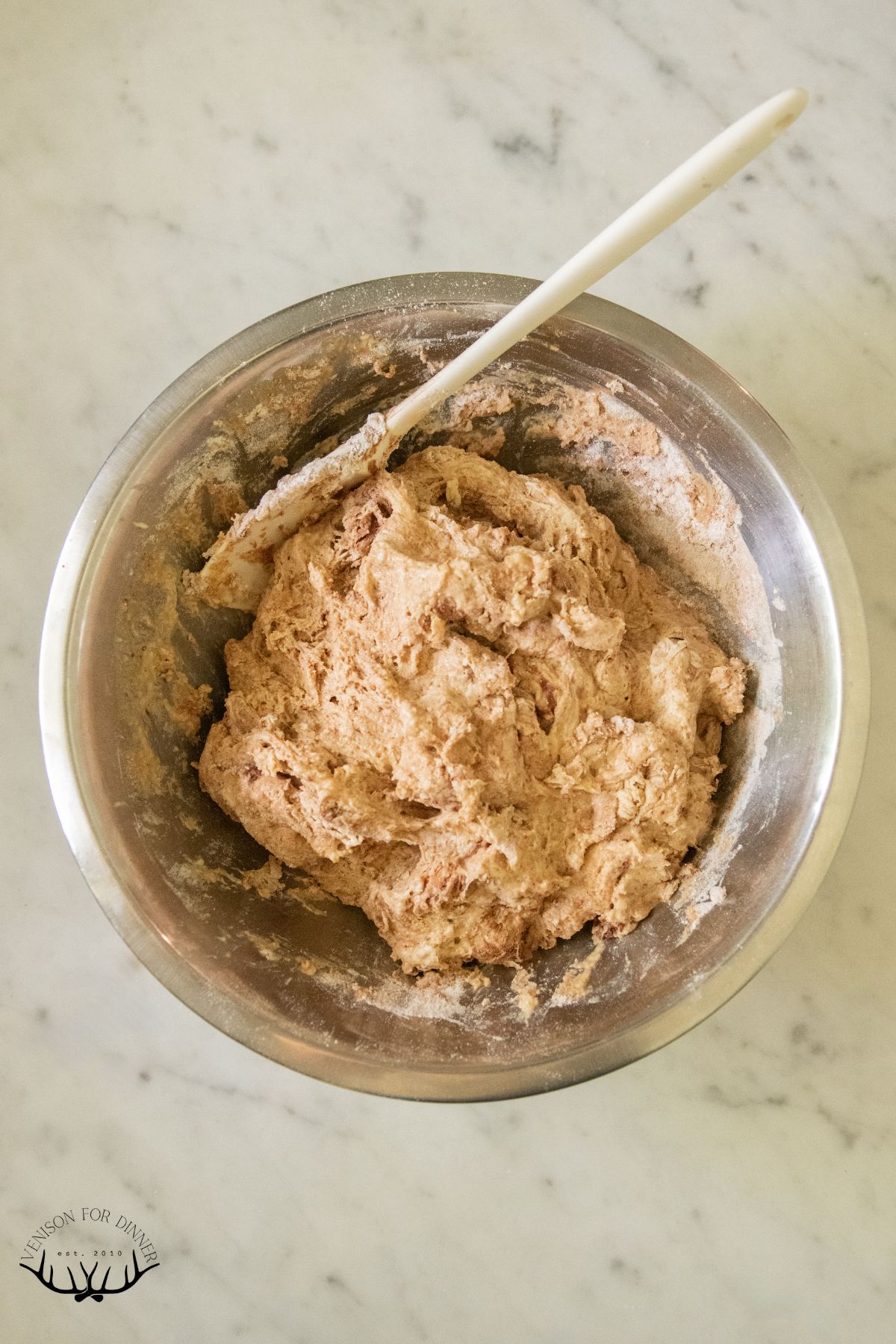 Shaggy brown bread dough in a bowl.