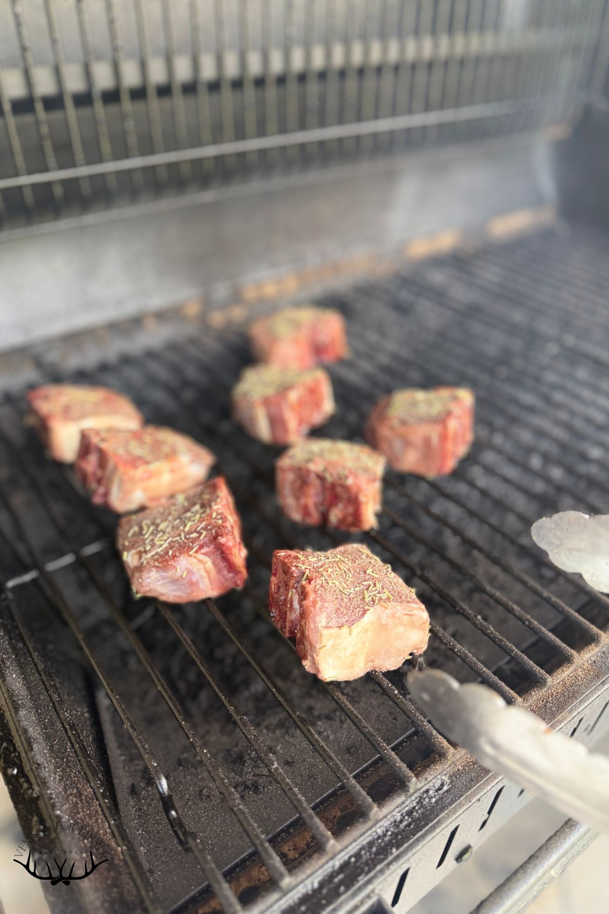Flipping lamb chops while grilling.
