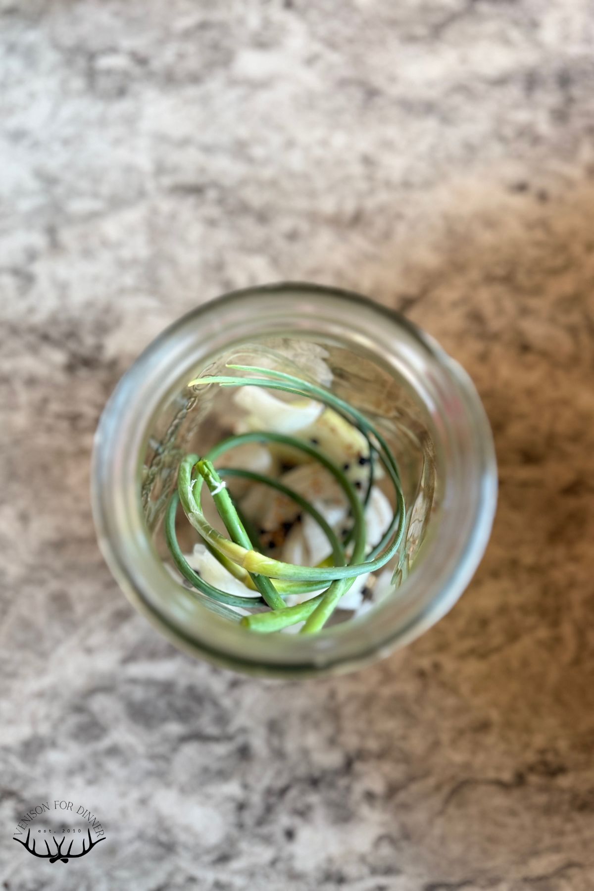 Garlic scapes and spices in a mason jar.